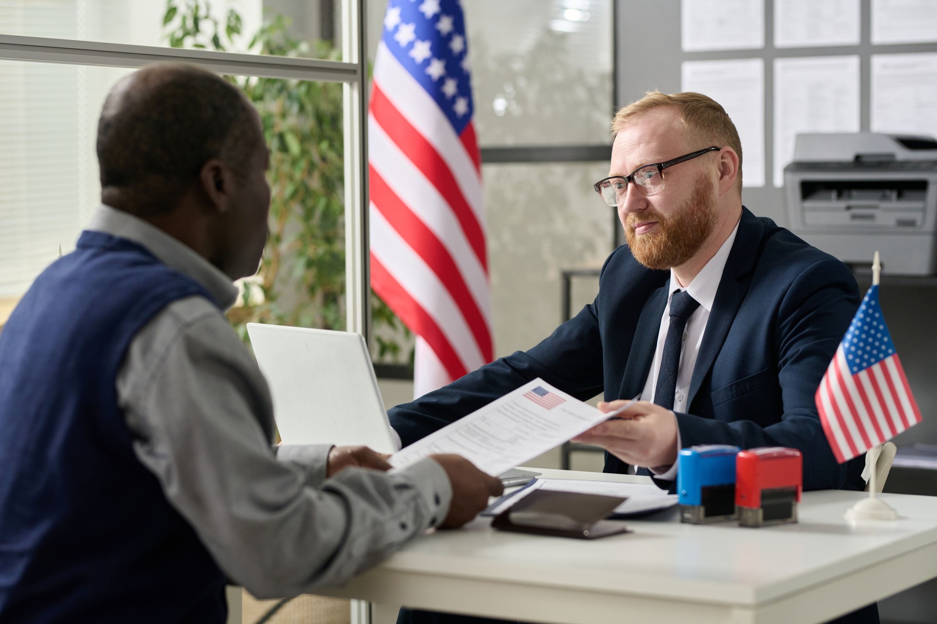 Worker handing visa application to man
